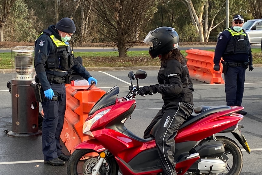 Police talk to person on motorbike