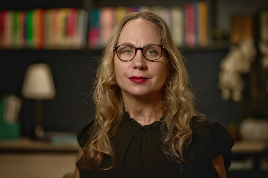 Dr Divna Haslam wears glasses and red lipstick.