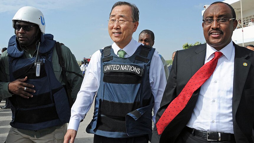 Ban Ki-moon (C) walks with Somali PM Abdiweli Mohamed Ali on his arrival in Mogadishu.
