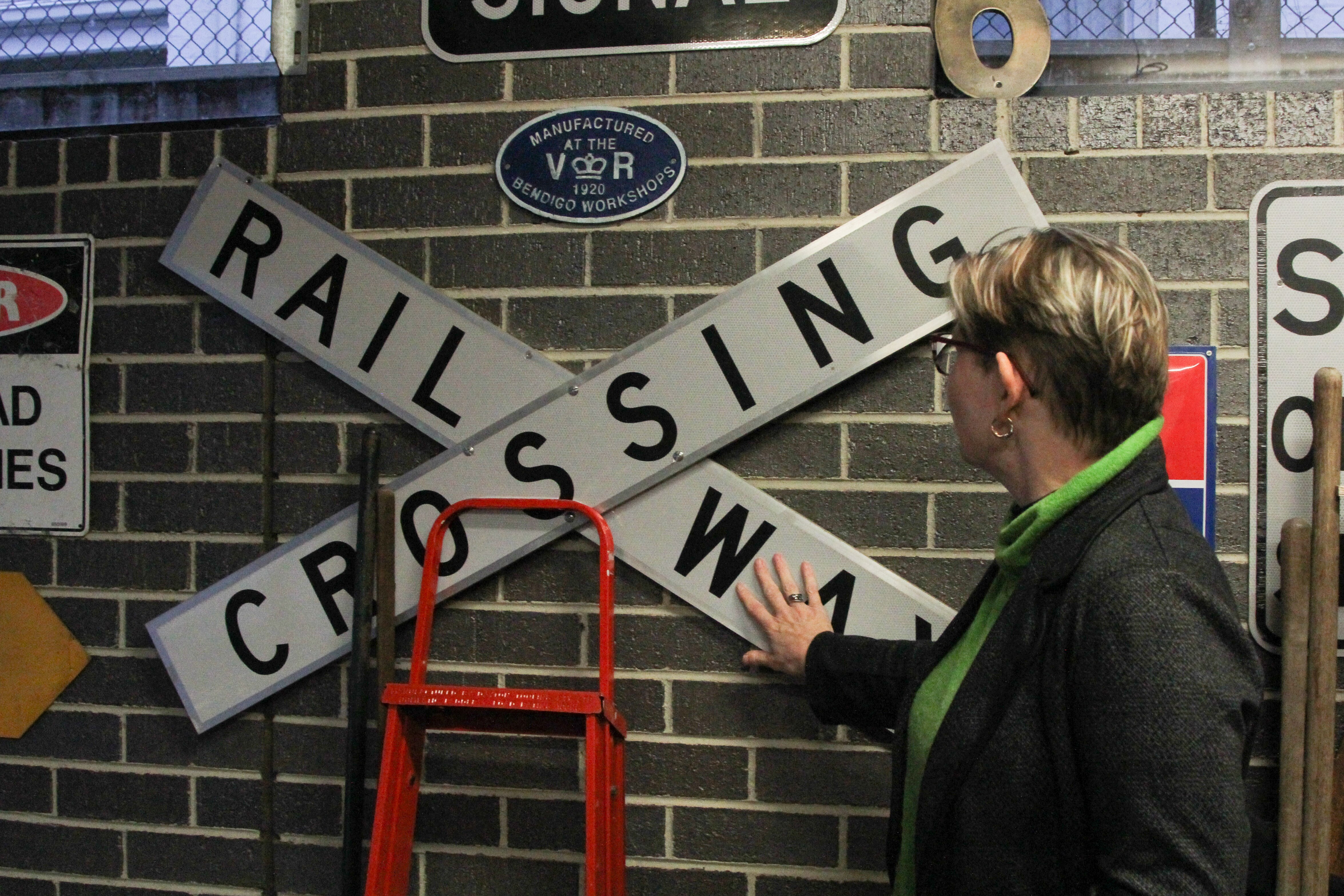 A woman looking at a railway crossing sign on a garage wall