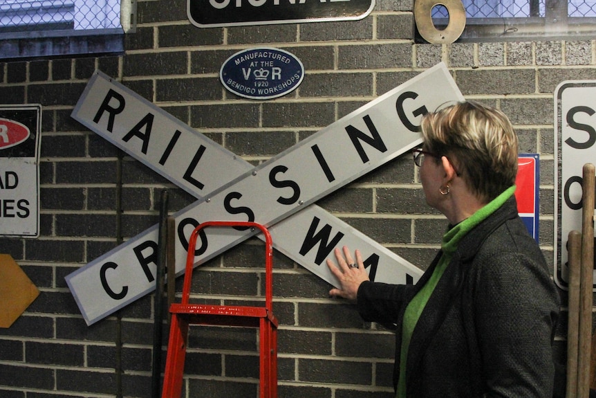 A woman looking at a railway crossing sign on a garage wall