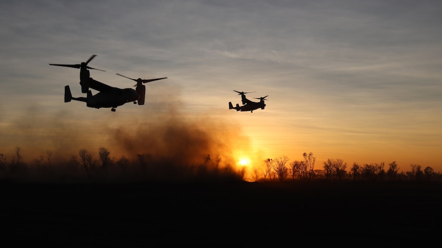 Planes fly over smokey bushland at dawn