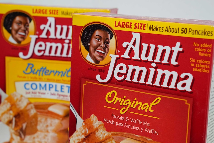 Two red boxes containing pancake mix are seen against a white background. The red and yellow boxes have a black woman on left.
