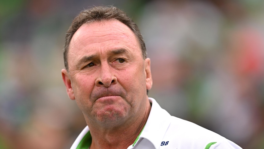 Rugby league coach Ricky Stuart, in a white polo shirt, looking concerned during a match