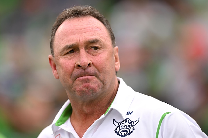 Rugby league coach Ricky Stuart, in a white polo shirt, looking concerned during a match