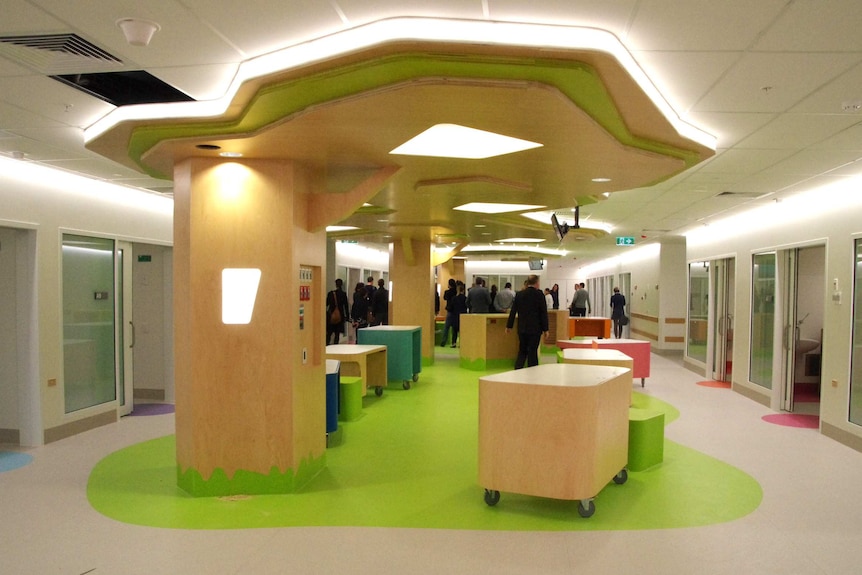 A wide interior shot of a ward at Perth Children's Hospital, with a crowd of people at the back of the room.