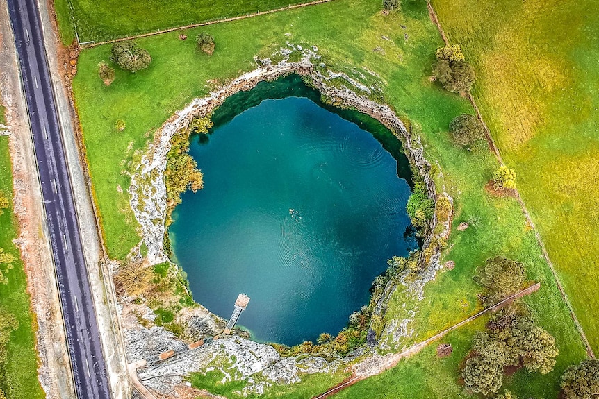 Round blue lake surrounded by paddocks