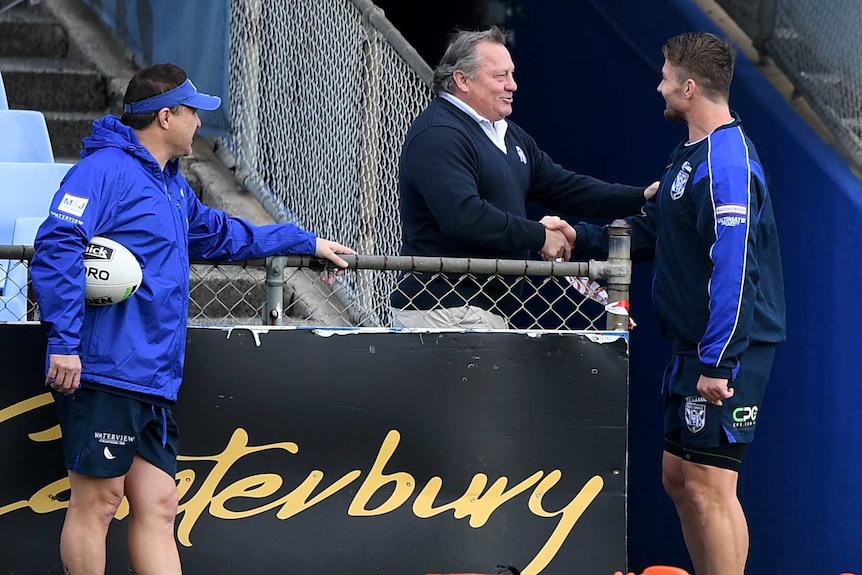 Terry Lamb shakes hands with Kieran Foran and puts his left hand on Foran's shoulder