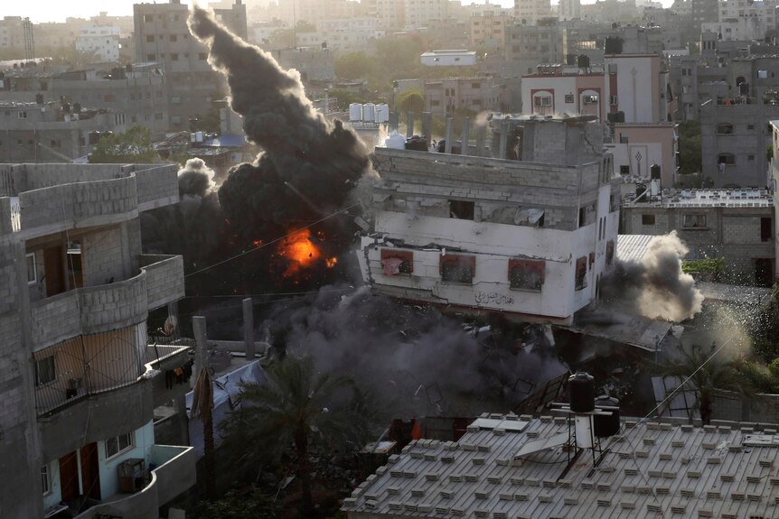 Smoke and fire rise from an explosion caused by an Israeli airstrike targeting a building in Gaza.