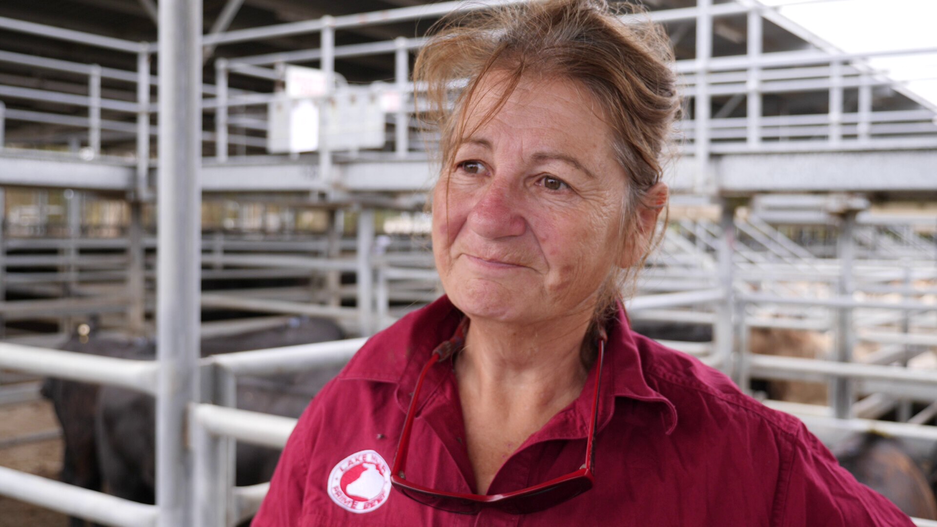 A woman in a pink shirt at a cattle sale