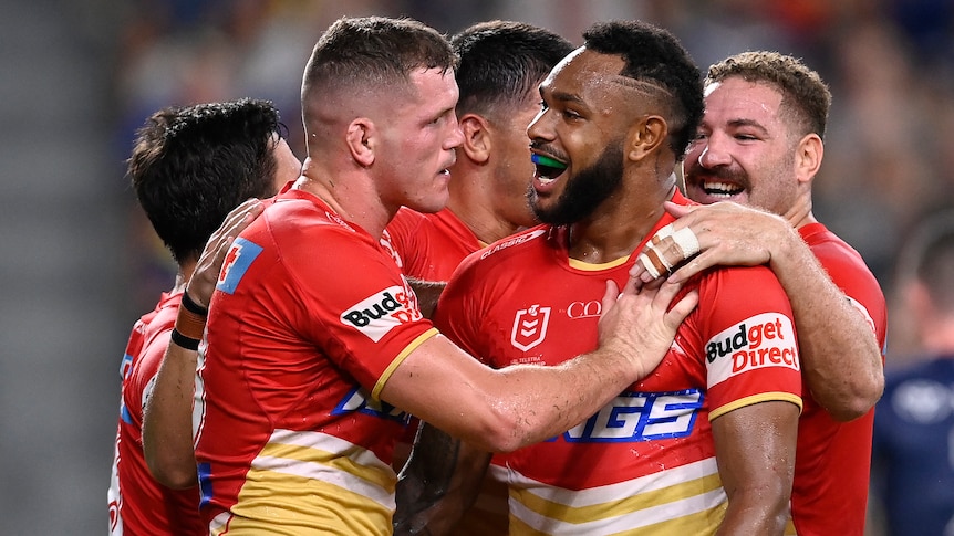 Dolphins NRL player embrace as they celebrate a try against the North Queensland Cowboys.