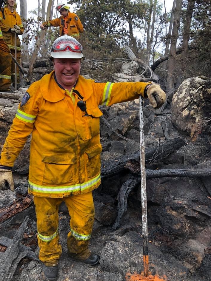 Wellington Fire Brigade crews in burnt landscape.