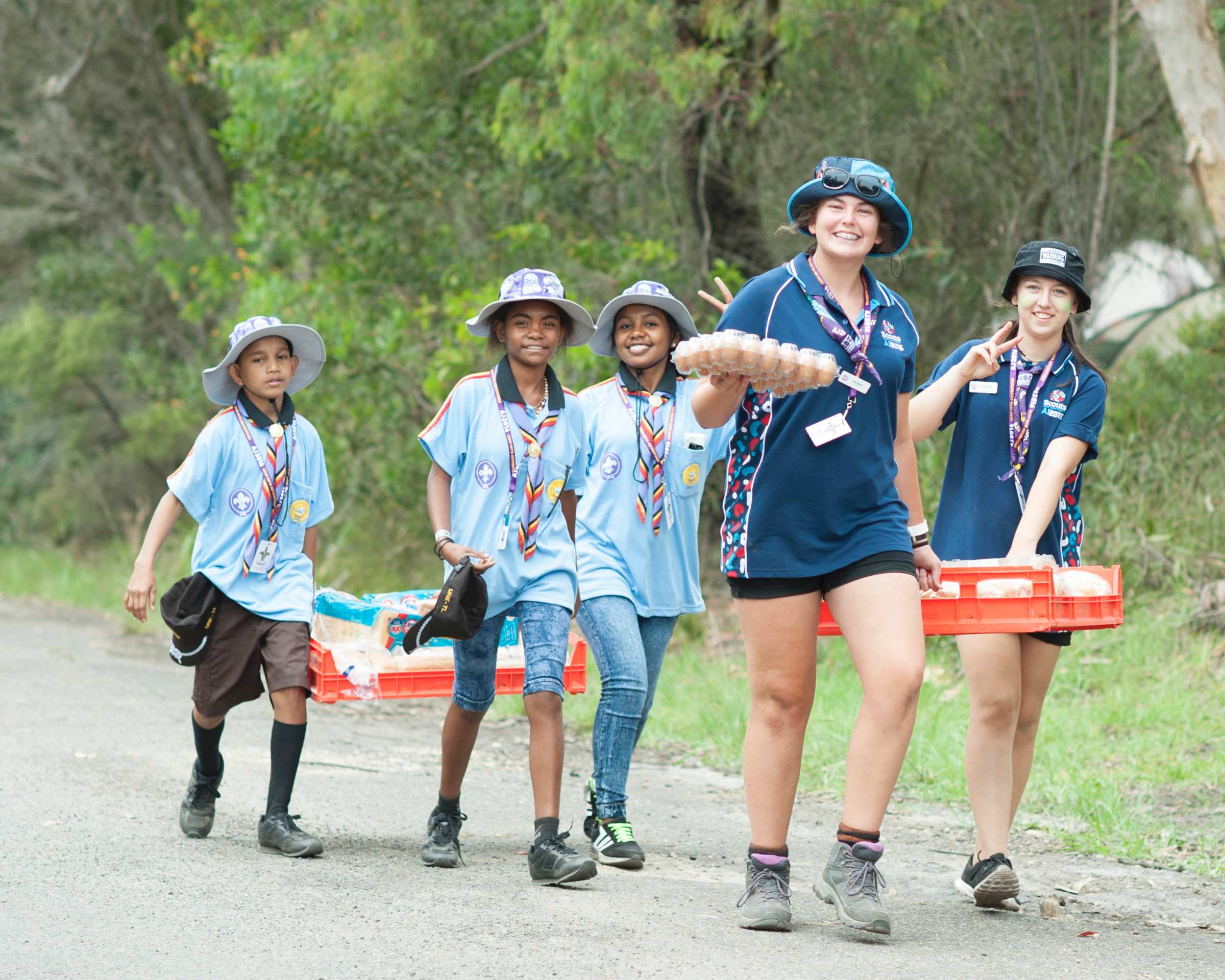 Scouts in blue uniforms carrying bread and eggs at the Jamboree in New South Wales.