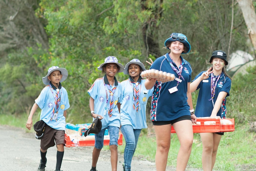 Scouts in blue uniforms carrying bread and eggs at the Jamboree in New South Wales.