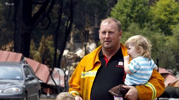 A CFA firefighter spends time with his children at Kinglake