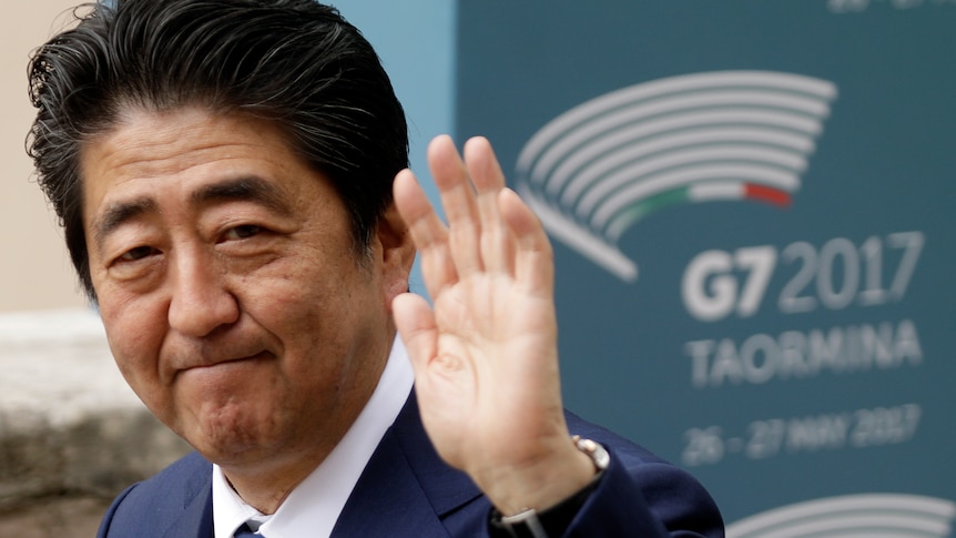 Japan Prime Minister Shinzo Abe waves outside the G7 ceremony in 2017.