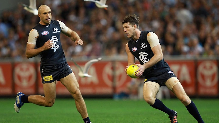 Carlton's Bryce Gibbs (R) with the ball with team-mate Chris Judd looking on.