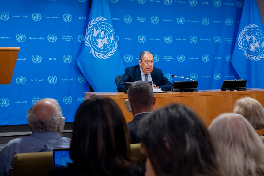 Russia Foreign Minister Sergey Lavrov speaks at a media briefing while sitting in front of a blue UN backdrop.