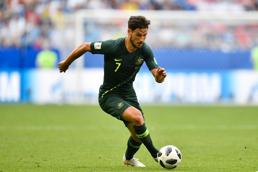 Mathew Leckie runs with the ball against Denmark