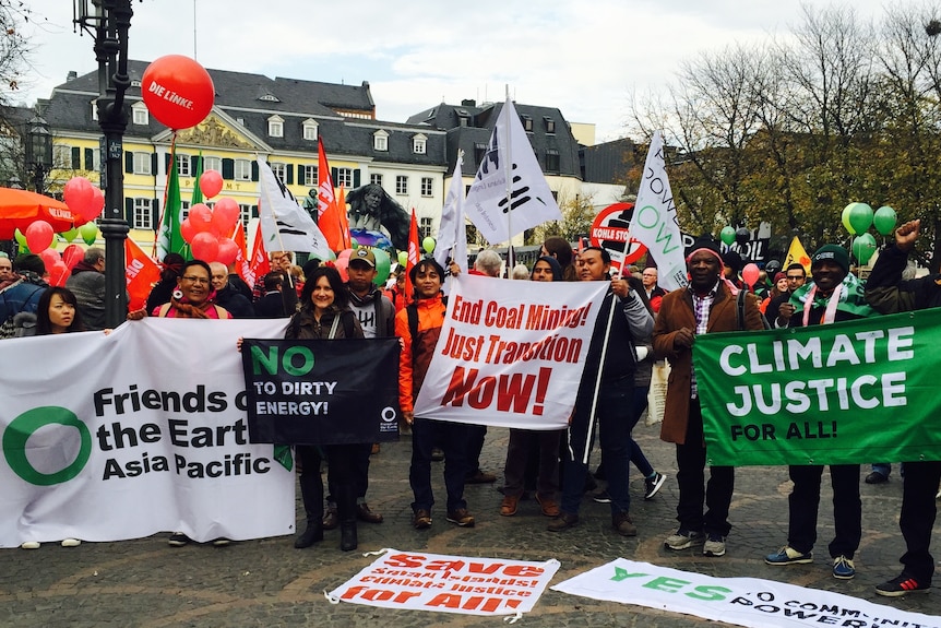 A group of Pacific protesters hold climate justice banners in the street in Bonn, Germany. 