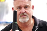 man with beard holding black metal stick