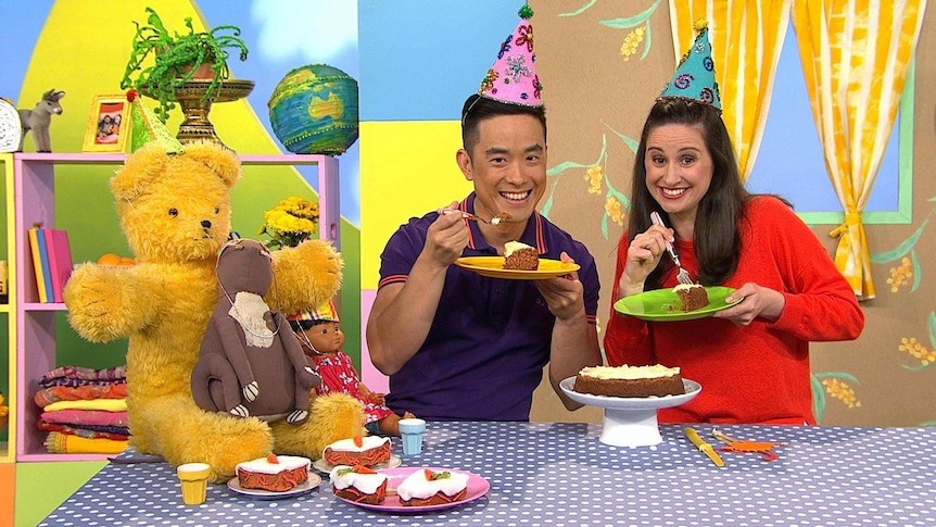 Kaeng and Emma with the Play School toys wearing party hats and eating cake