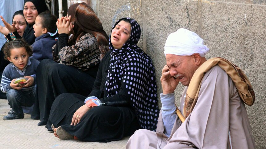 Relatives of Morsi supporters cry outside court after it ordered mass death sentences