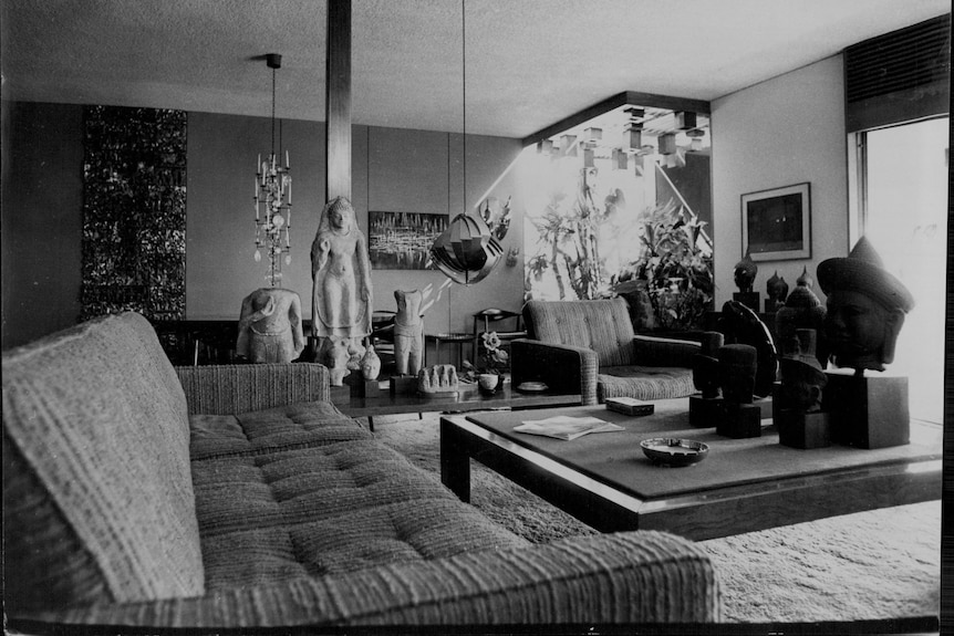Black and white image of a mid-century modern living room full of sculptures