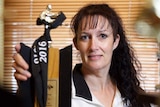 Tracy Ellis shows off her karate trophies