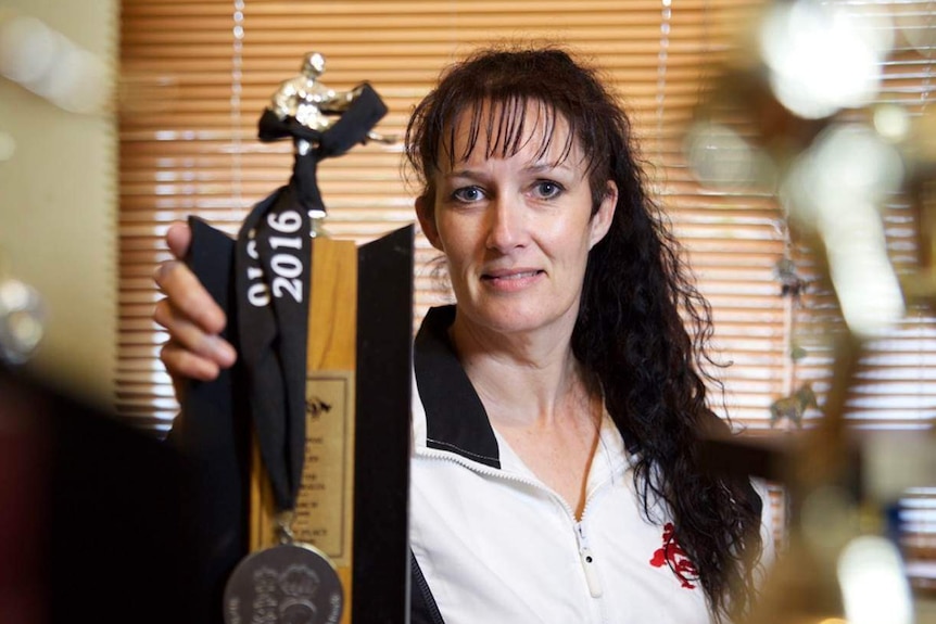 Tracy Ellis shows off her karate trophies