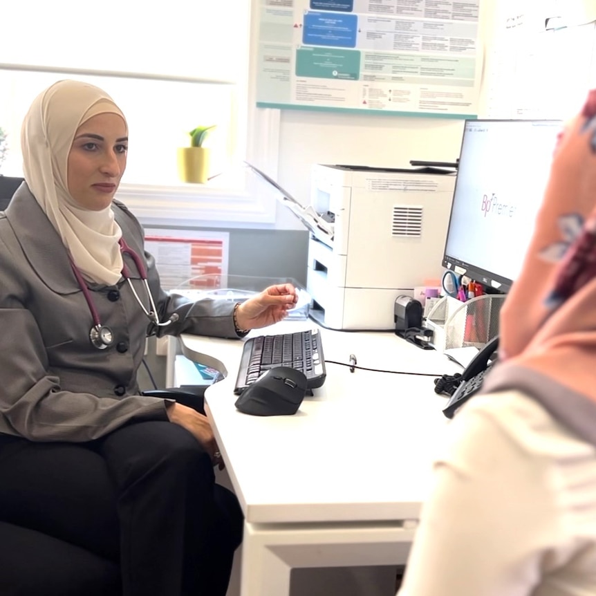 Dr Amireh at her desk seeing a patient.