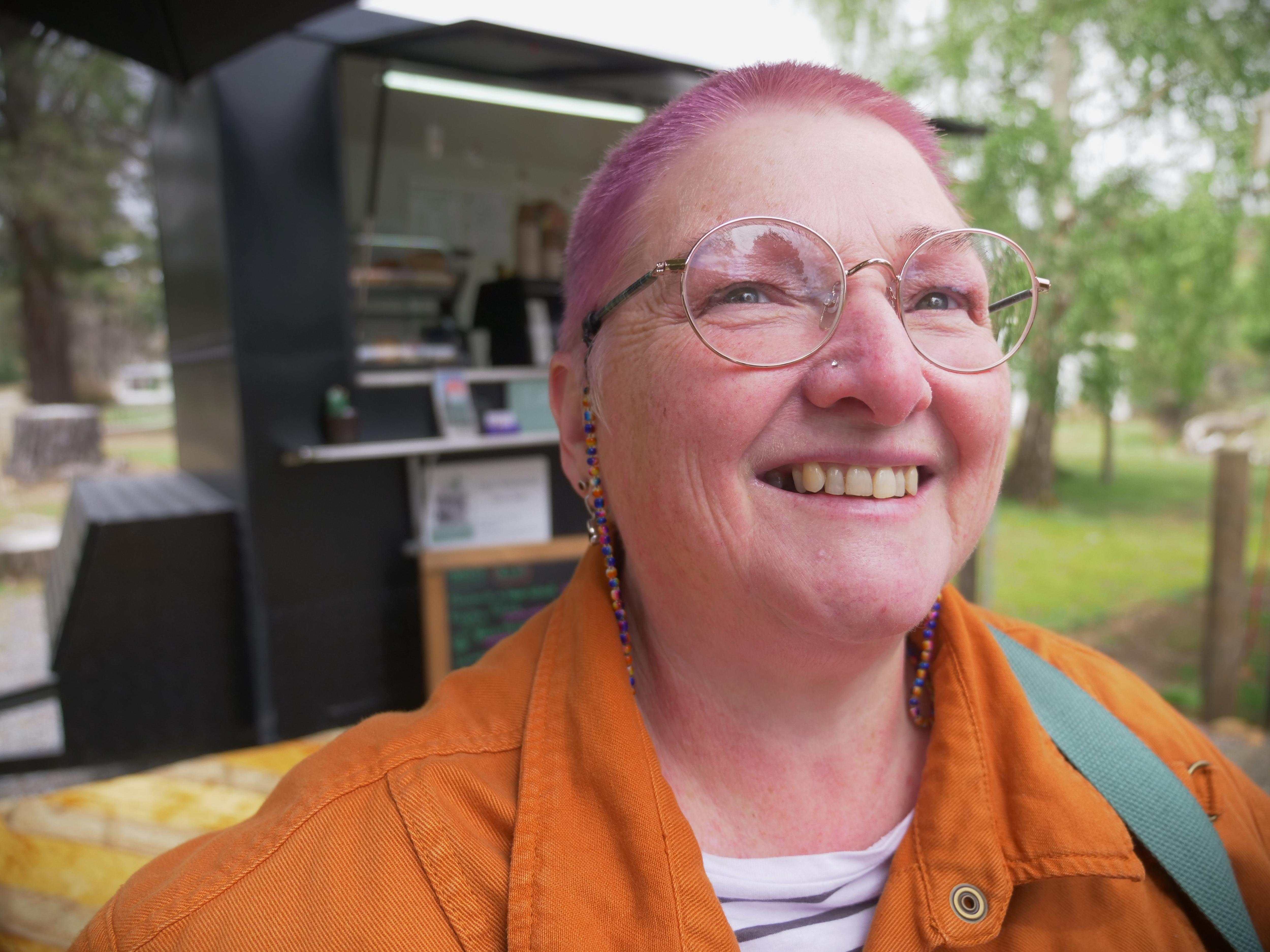 selfie type photo of woman wearing orahe hi-vi shirt and smiling 