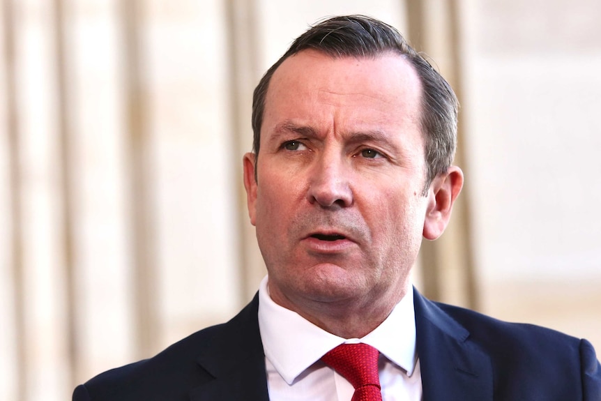 WA Premier Mark McGowan speaks at a media conference at Parliament in West Perth wearing a suit and red tie.