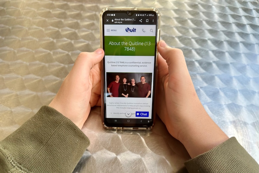 photo of hands on a mobile phone with the Quit line website pictured
