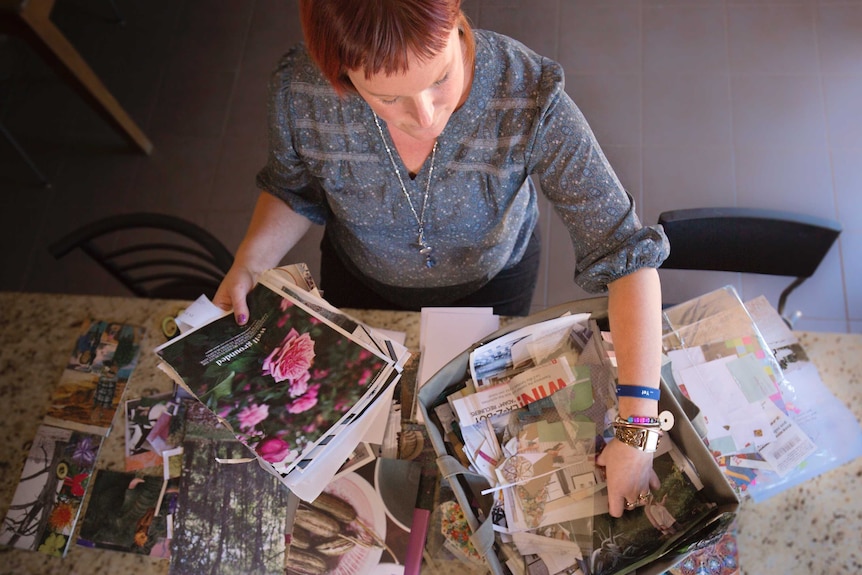 Leonie sits with a box of scrapbooking materials.