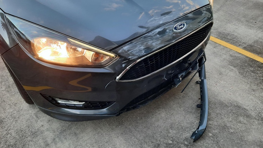 the front end of a car showing bumper damage