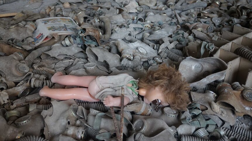 Doll lies in sea of gas masks on floor of cafeteria of school in Pripyat