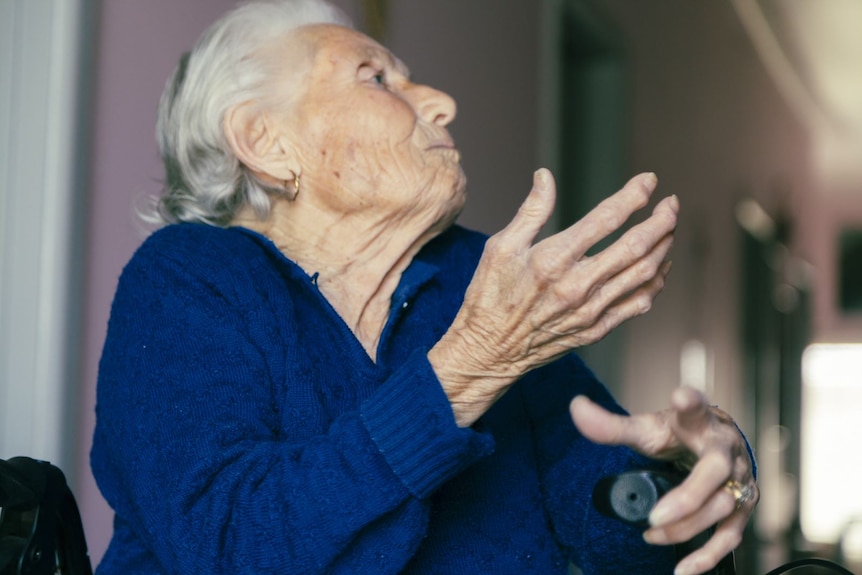 Francesca sits, singing with expressive hand gestures