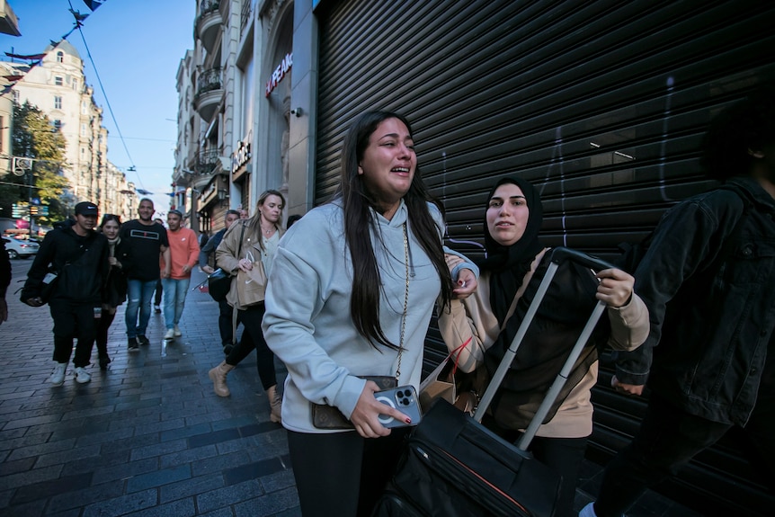 Woman crying as her and others flee from the scene of an explosion in central Istanbul.