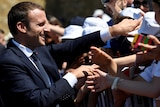 Emmanuel Macron smiles as he greets supporters.