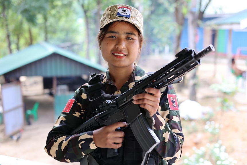 A woman holds a gun.