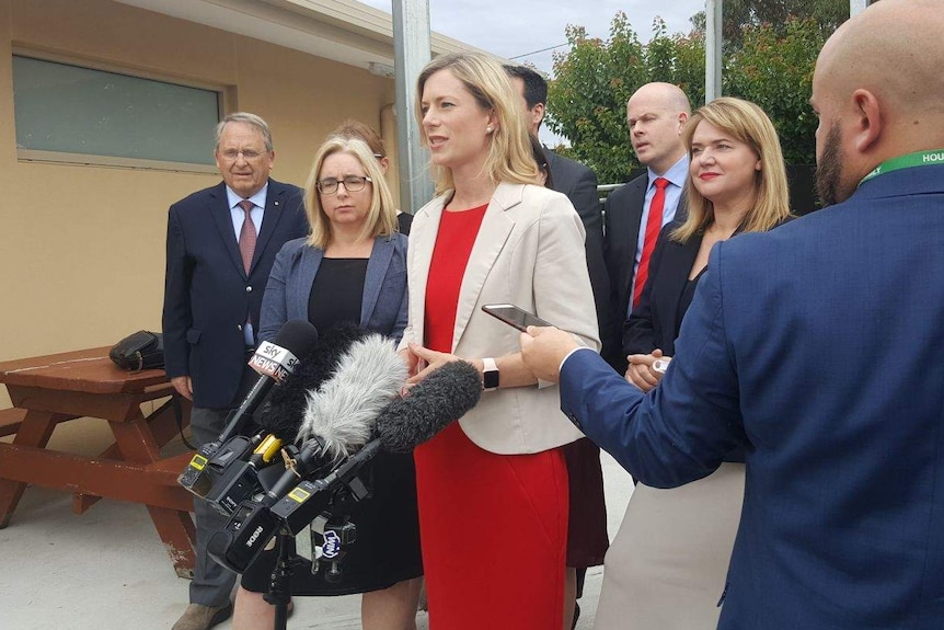 Labor leader Rebecca White announcing Labor's gambling policy. She stands with colleagues in front of microphones.