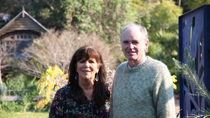 Woman and man standing together in a nursery smiling at the camera