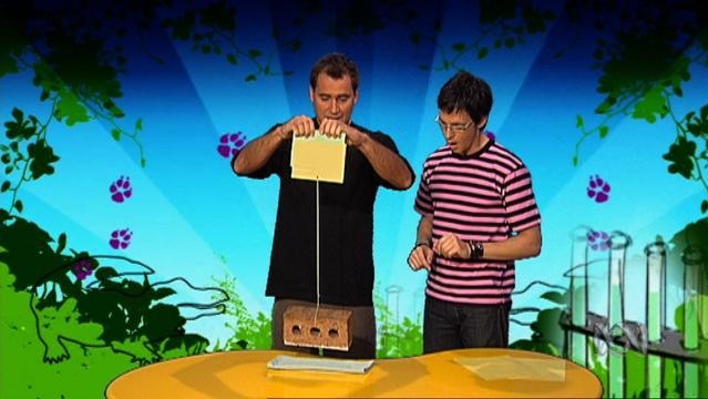 Two men hold up a brick by string
