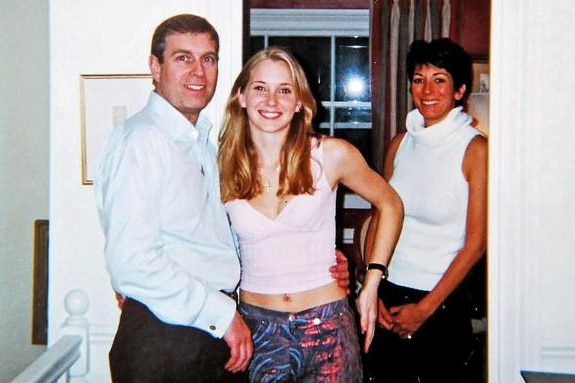 A man and two women stand in a house looking at the camera.