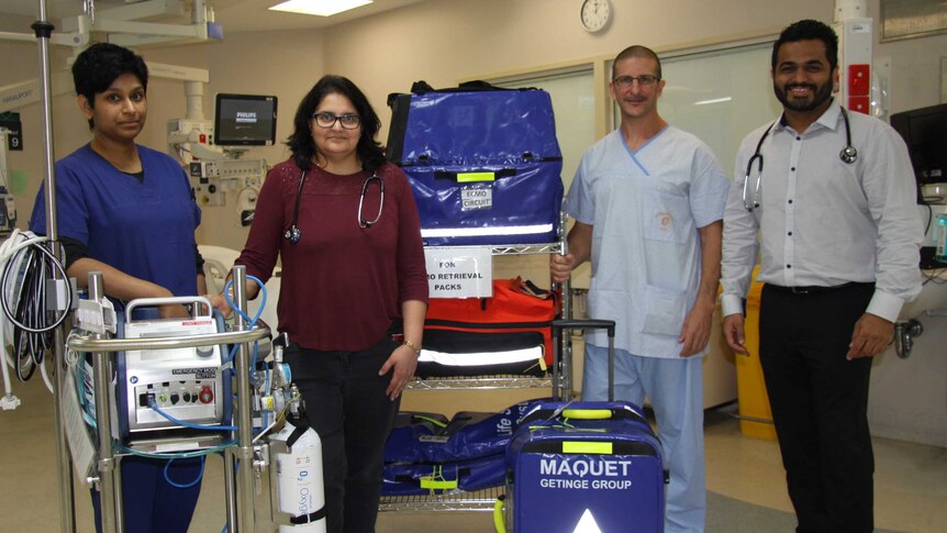 Staff from the Prince Charles Hospital and the ECMO machine.