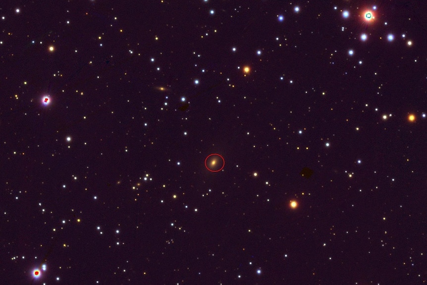 A red circle indicates the position of a specific galaxy on an image showing hundreds of constellations.