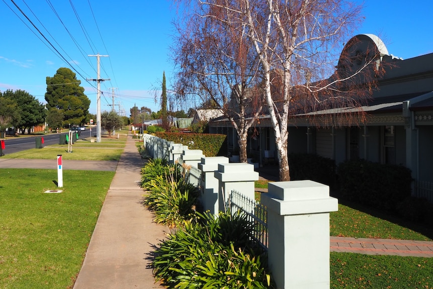 A row of period homes (blue) in Mildura taken from an adjacent angle with some lawn in view