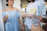 Women drinking lemon water while others drink white wine.