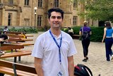 Mr Amiri stands on the lawns at the University of Melbourne.  He will graduate in December and hopes to work for the government.